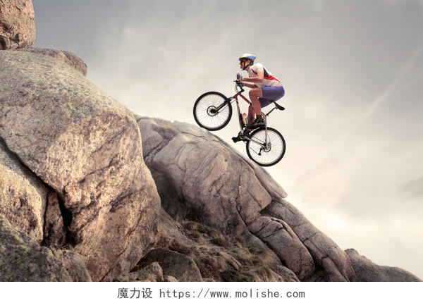 岩石上骑一辆山地自行车的极限运动者